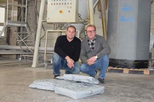 Norbert Gunkel und Michael Grede mit Anfahrklumpen aus Extrusionanlagen, aus denen jetzt Mahlgut hergestellt wird